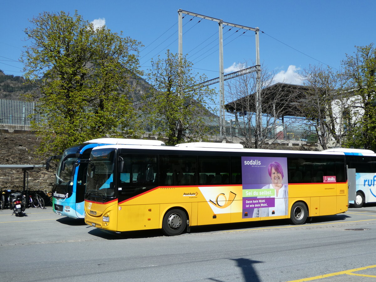 (248'321) - PostAuto Wallis - VS 445'904/PID 10'455 - Iveco am 9. April 2023 beim Bahnhof Brig