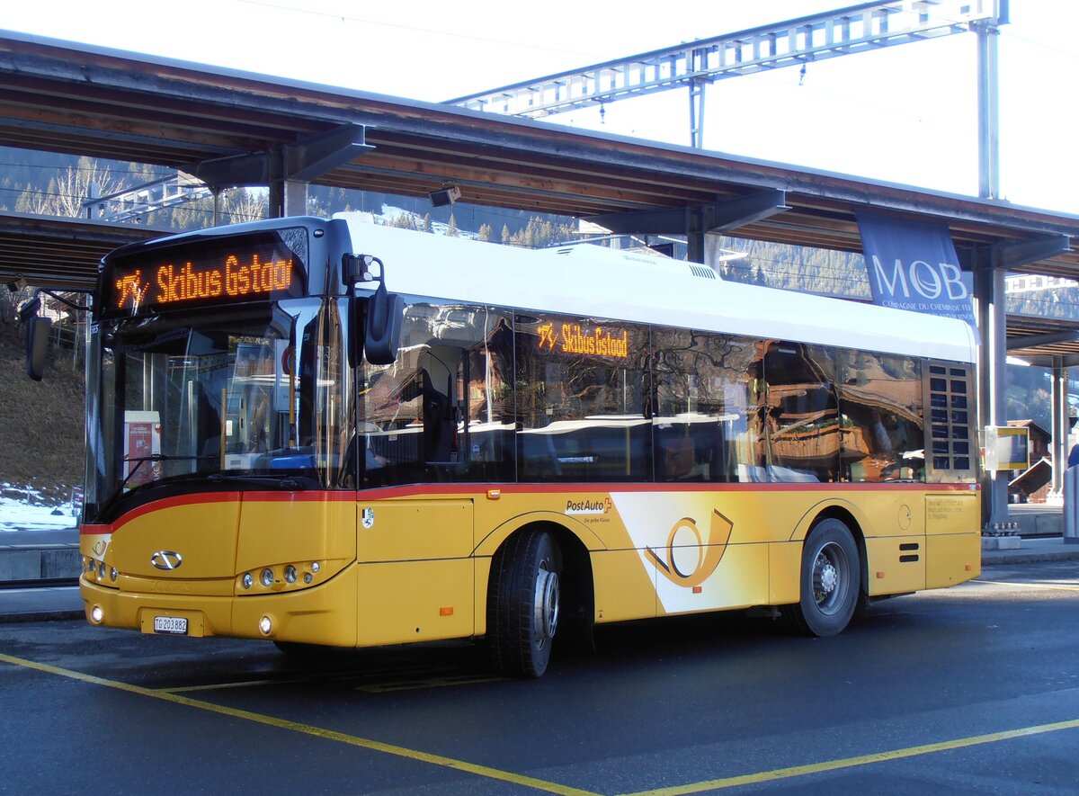 (257'936) - Mock+Weber, St. Pelagiberg - TG 203'882/PID 5565 - Solaris (ex PostAuto Ostschweiz; ex PostAuto Graubnden; ex PostAuto Ostschweiz; ex Postautobetriebe Unteres Toggenburg, Ltisburg) am 25. Dezember 2023 beim Bahnhof Gstaad